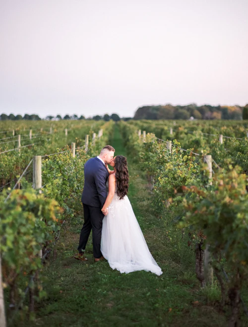 bride and groom kissing in the middle of a vineyard RG|NY