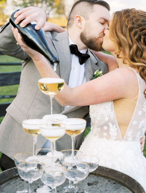 bride and groom kissing and him pouring a champagne tower RG|NY